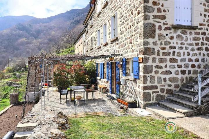 Le gîte au rez-de-chaussée aux volets bleus au printemps.